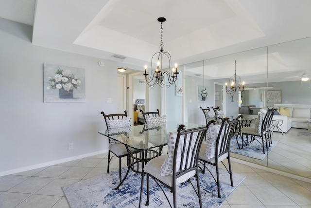 dining space featuring light tile patterned floors, ceiling fan with notable chandelier, and a raised ceiling