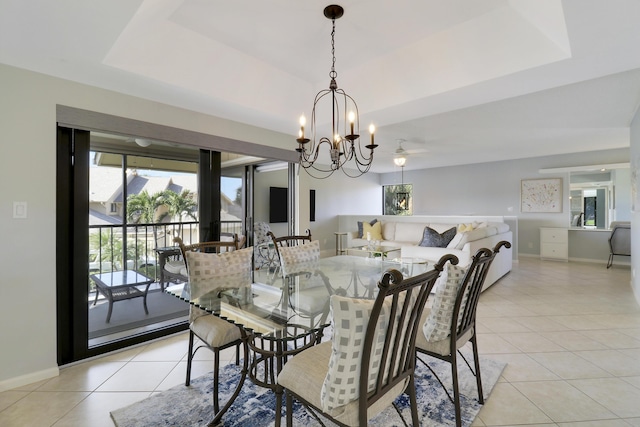 dining space featuring a chandelier, a raised ceiling, and light tile patterned flooring