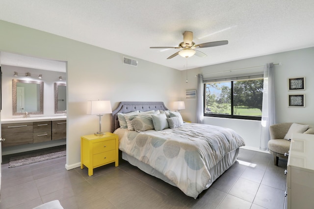 tiled bedroom featuring ceiling fan, sink, and a textured ceiling