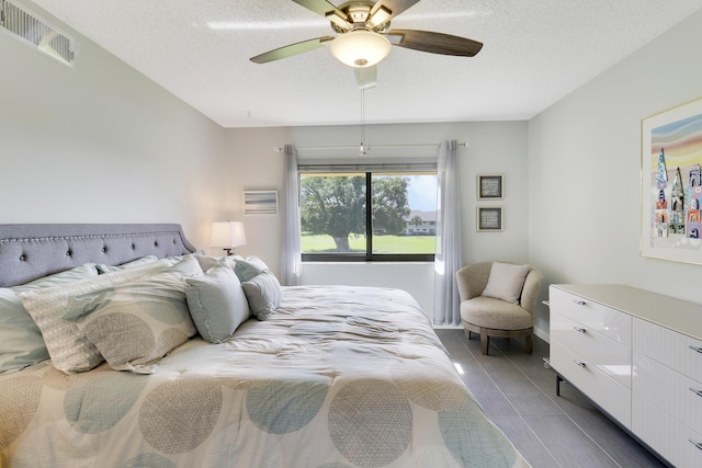 bedroom with ceiling fan and a textured ceiling