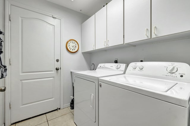 laundry area with cabinet space, light tile patterned floors, and independent washer and dryer