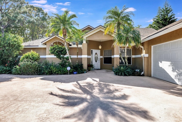 view of front of home featuring concrete driveway, an attached garage, and stucco siding