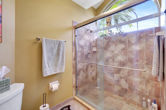 bathroom with a stall shower and toilet