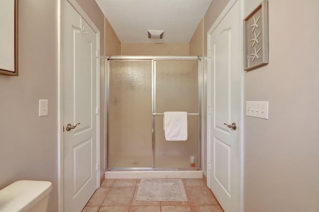 full bath with visible vents, a shower stall, toilet, and tile patterned floors