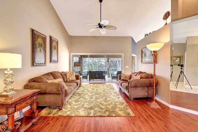 living room featuring ceiling fan, high vaulted ceiling, wood finished floors, and baseboards