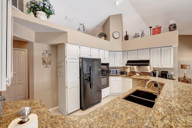 kitchen featuring light tile patterned floors, a sink, light stone countertops, under cabinet range hood, and black appliances