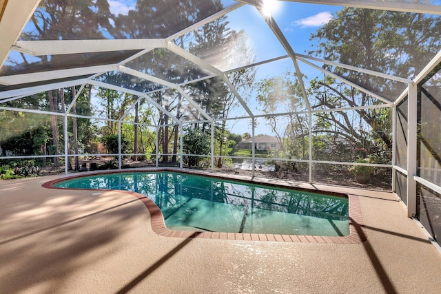 outdoor pool with a patio area and glass enclosure