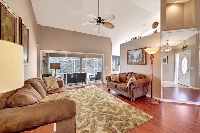 living area featuring high vaulted ceiling, wood finished floors, a ceiling fan, and baseboards