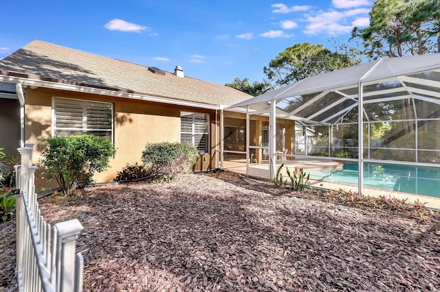 back of property with a patio, a lanai, roof with shingles, an outdoor pool, and stucco siding