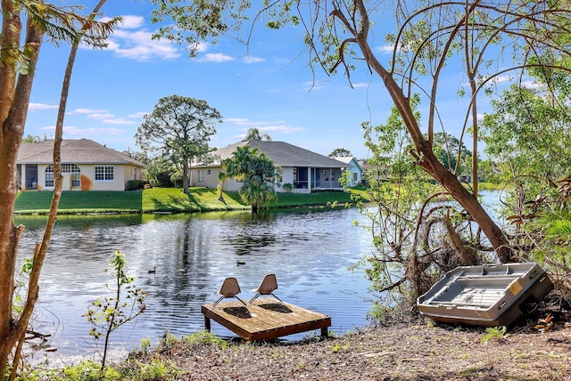 view of dock featuring a water view and a lawn