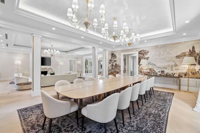 dining room with a fireplace, ornamental molding, ornate columns, and a raised ceiling