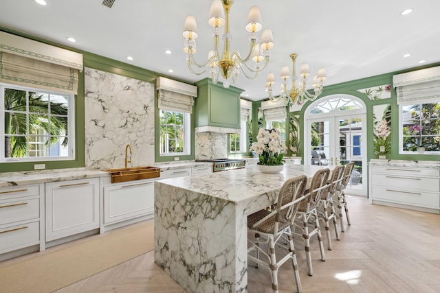 kitchen featuring a center island, light parquet flooring, white cabinetry, sink, and backsplash