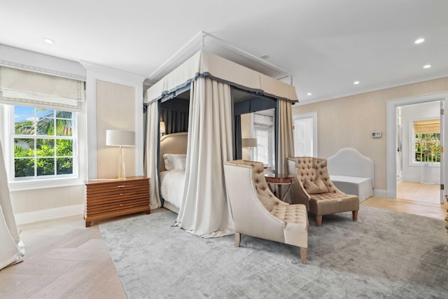 bedroom featuring crown molding, light parquet floors, and ensuite bath