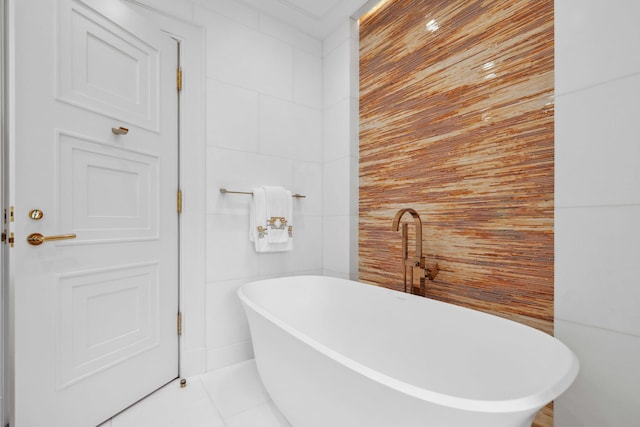 bathroom with tile patterned floors and a bath