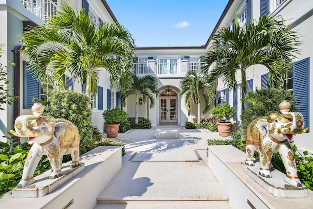 view of front of home with a balcony, french doors, and a patio