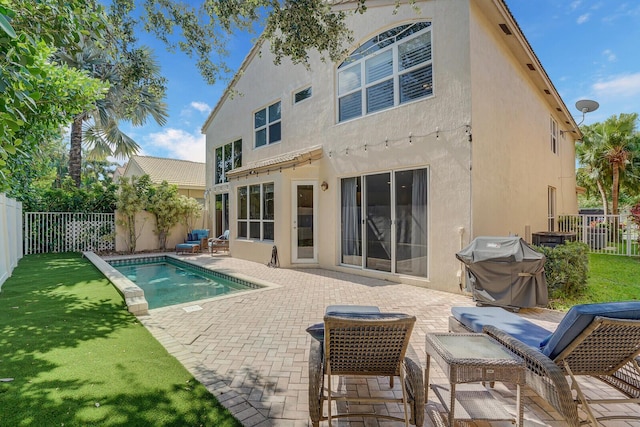 rear view of house featuring a patio area and a fenced in pool