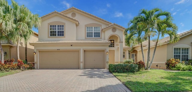 mediterranean / spanish house featuring a front yard and a garage