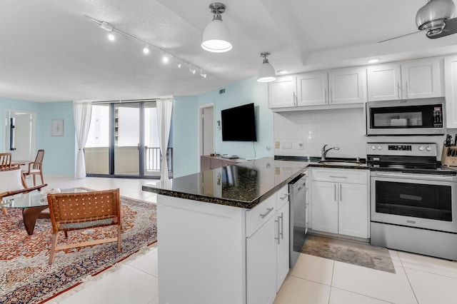 kitchen with decorative backsplash, stainless steel appliances, sink, decorative light fixtures, and white cabinetry