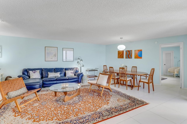 living room with a textured ceiling and light tile patterned flooring