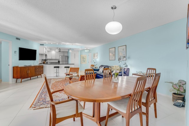 dining room featuring light tile patterned floors and a textured ceiling