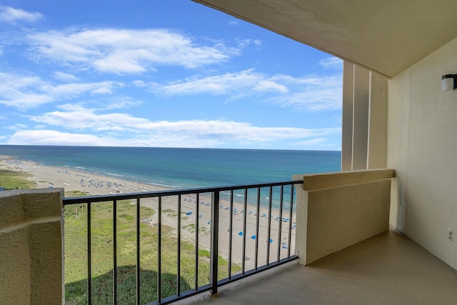 balcony featuring a view of the beach and a water view