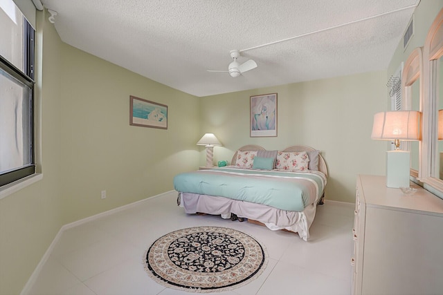 bedroom featuring a textured ceiling, tile patterned floors, and ceiling fan