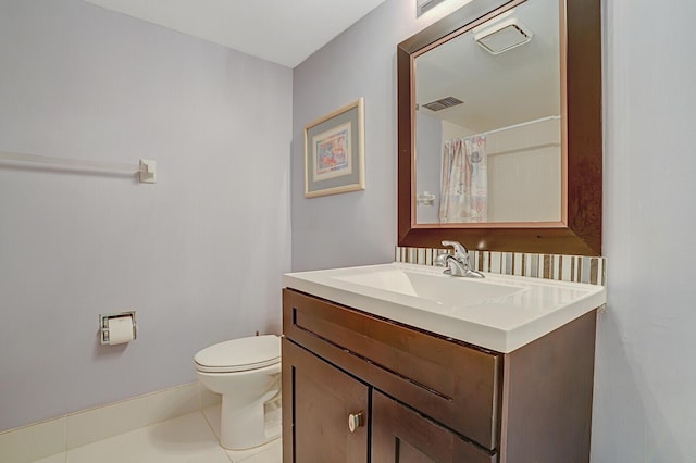 bathroom with tile patterned flooring, vanity, and toilet