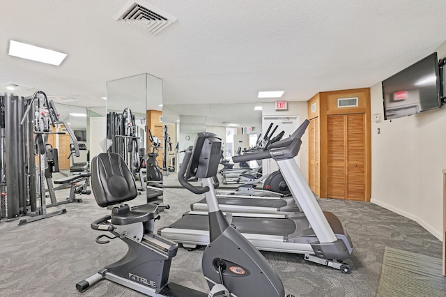 workout area with carpet flooring and a textured ceiling