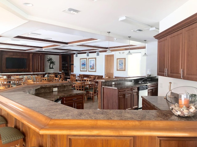 kitchen featuring dishwasher, dark stone counters, sink, decorative light fixtures, and kitchen peninsula