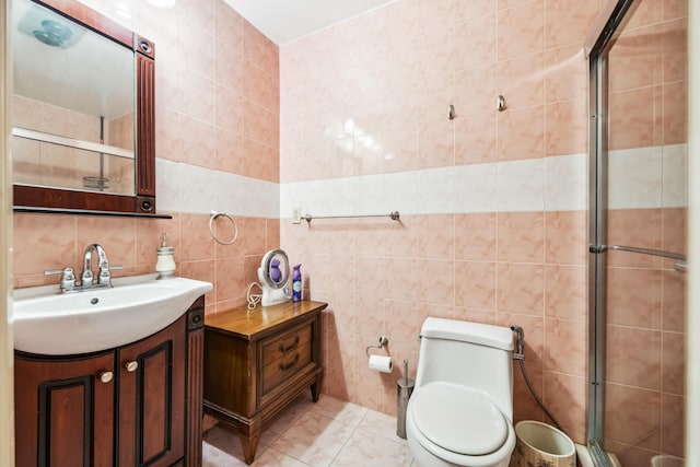 bathroom featuring vanity, tile patterned floors, toilet, tile walls, and an enclosed shower