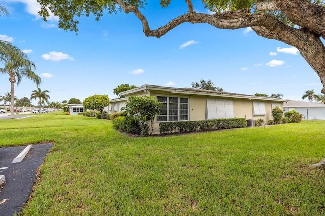 view of front of property featuring central AC and a front yard