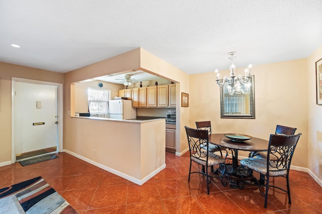 kitchen featuring kitchen peninsula, ceiling fan with notable chandelier, light brown cabinets, tile patterned flooring, and white fridge