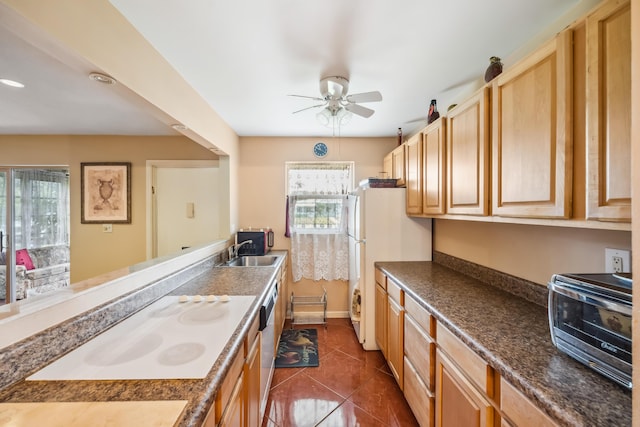 kitchen featuring light brown cabinets, white appliances, sink, ceiling fan, and dark tile patterned floors