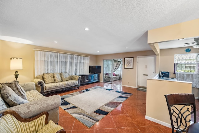 living room featuring a textured ceiling, tile patterned floors, and ceiling fan