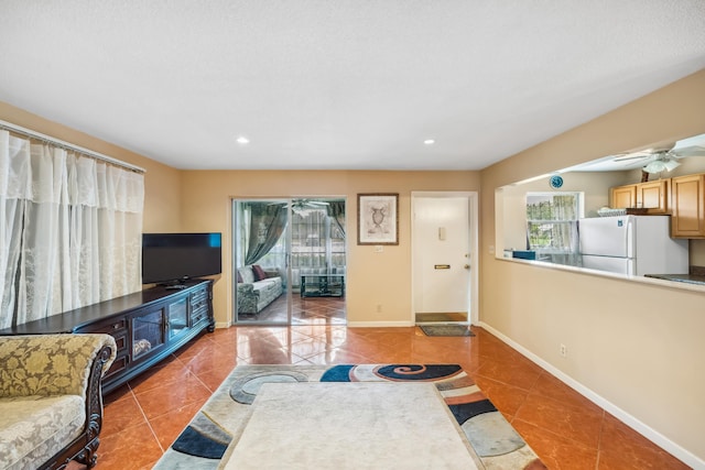 tiled living room with ceiling fan