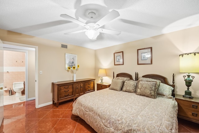 bedroom featuring dark tile patterned flooring, ceiling fan, a textured ceiling, and ensuite bath