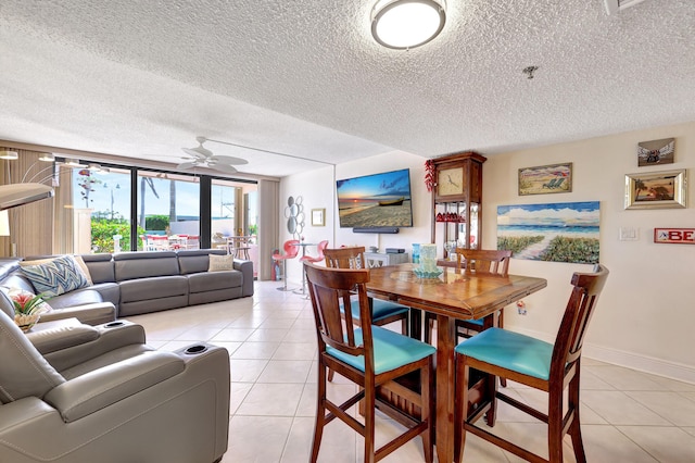 tiled dining space with a textured ceiling and ceiling fan