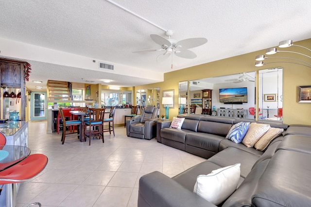 tiled living room with a textured ceiling and ceiling fan