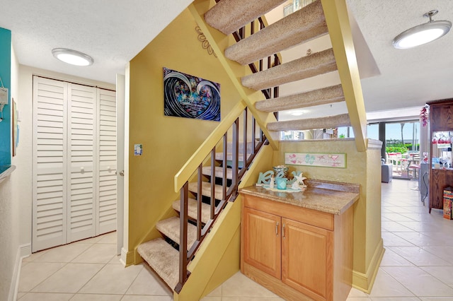 stairs with tile patterned flooring and a textured ceiling