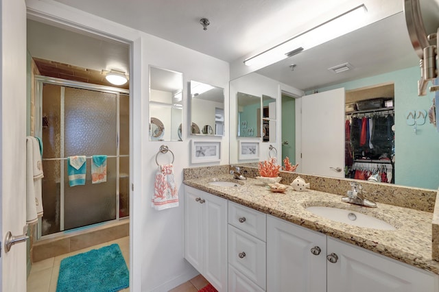 bathroom featuring vanity, tile patterned flooring, and a shower with shower door