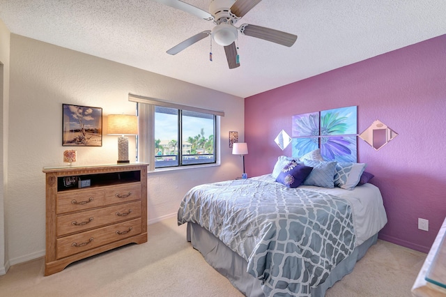 bedroom featuring light carpet, ceiling fan, and a textured ceiling