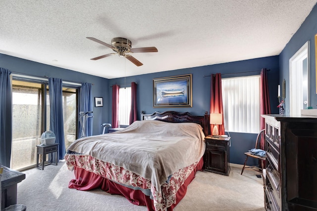 carpeted bedroom featuring a textured ceiling and ceiling fan