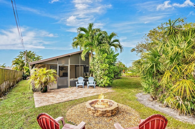 view of yard with a sunroom, a patio, and a fire pit