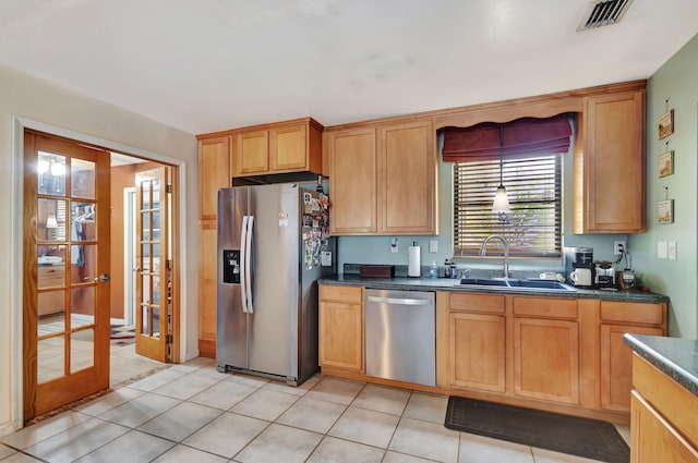 kitchen with sink, light tile patterned floors, and stainless steel appliances