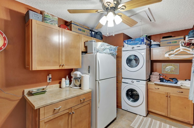 clothes washing area with light tile patterned floors, a textured ceiling, stacked washer and dryer, and ceiling fan