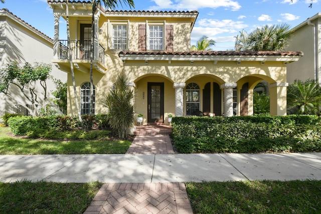 mediterranean / spanish house with a balcony and a porch