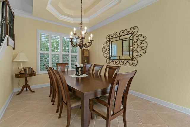 dining area with light tile patterned floors, an inviting chandelier, a raised ceiling, and crown molding