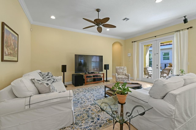 tiled living room with ceiling fan, french doors, and crown molding