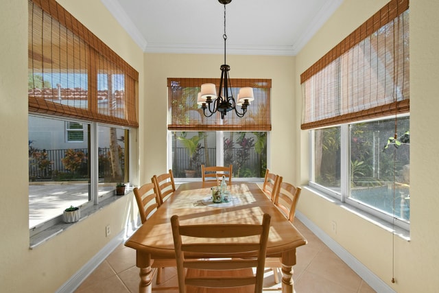 tiled dining room with a healthy amount of sunlight, an inviting chandelier, and ornamental molding