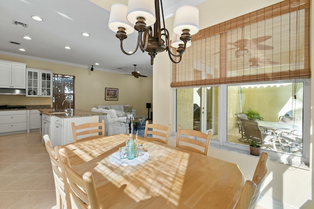 dining room with crown molding, sink, light tile patterned floors, and ceiling fan with notable chandelier